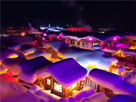 Hình ảnh đẹp về ngôi làng tuyết phủ trong đêm khi ánh đèn chiếu sáng