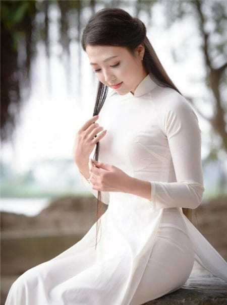 Hình ảnh cô gái xinh đẹp với tà áo trắng ngồi tạo dáng với mái tóc dài